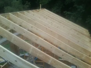 New roof rafters set over an addition before sheathing in Howard